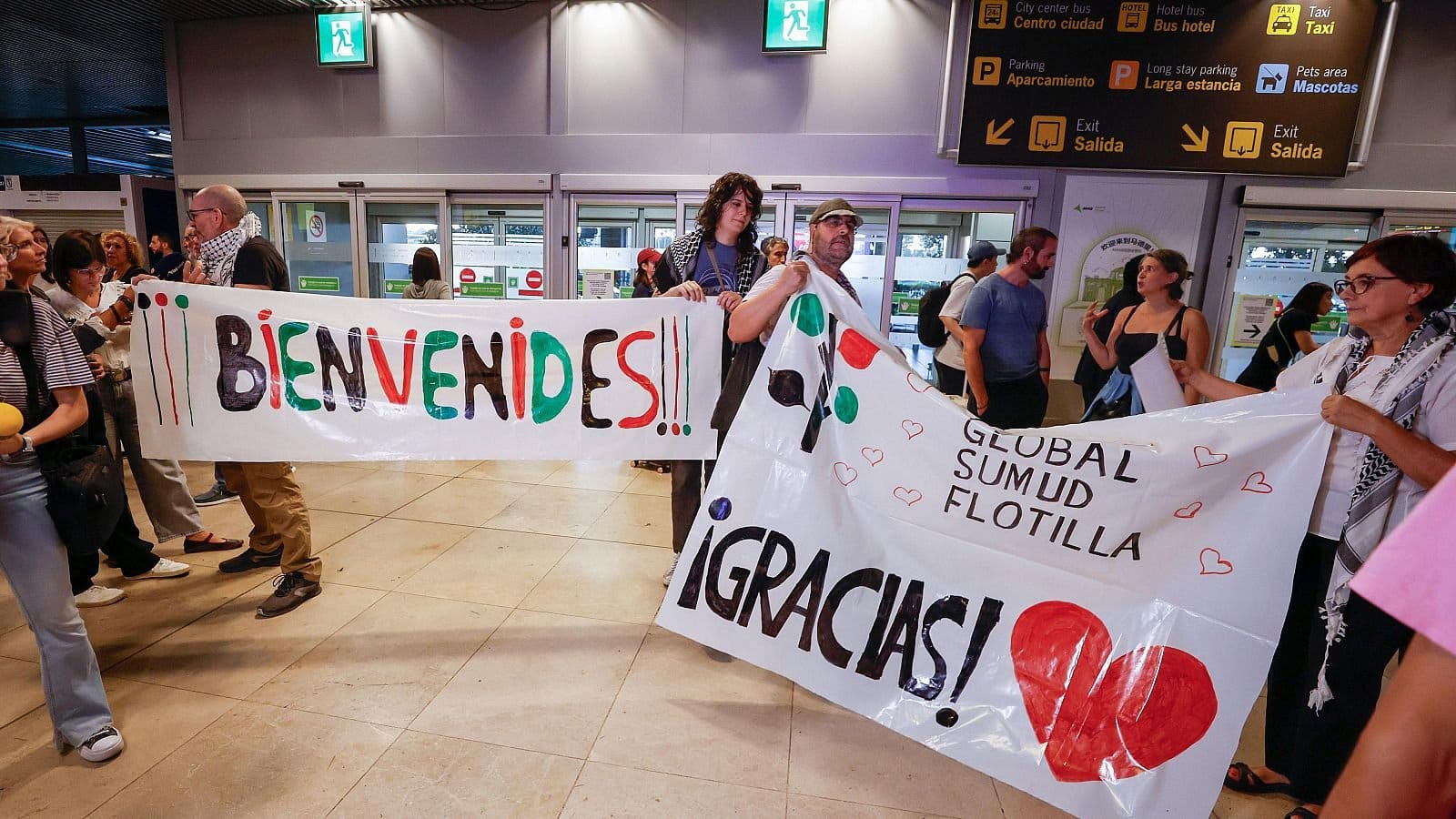 Varias personas preparando la bienvenida a activistas de la Global Sumud Flotilla en Barajas. Foto: @NuriaSuarez_R0 (X)