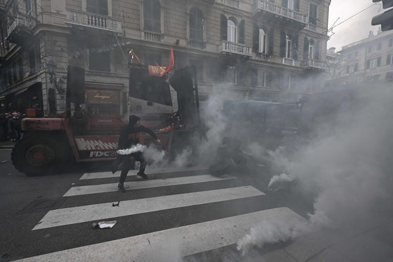 Un huelguista trata de devolver los botes de gas a la policía. Foto: genova24.it