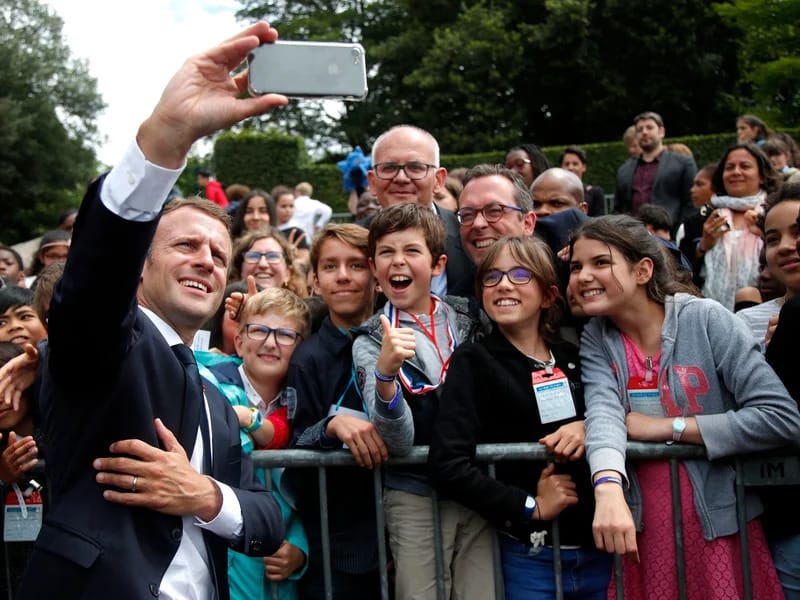 Imagen de archivo del presidente francés Emmanuel Macron sacándose una foto con adolescentes y adultos. Foto: Charles Platiau/Getty Images