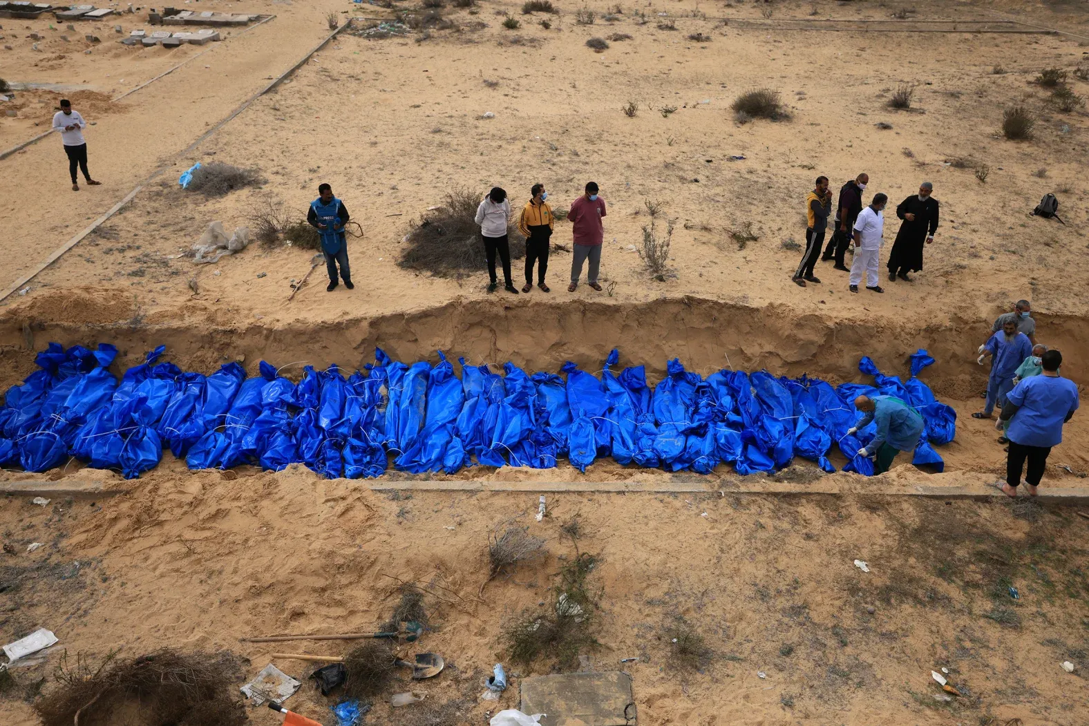 Palestinos entierran cadáveres procedentes de los hospitales Indonesio y Al-Shifa en una fosa común en el cementerio de Khan Yunis, sur de Gaza, 22 de noviembre del 2023. Foto: Mahmud Hams/AFP/Getty Images