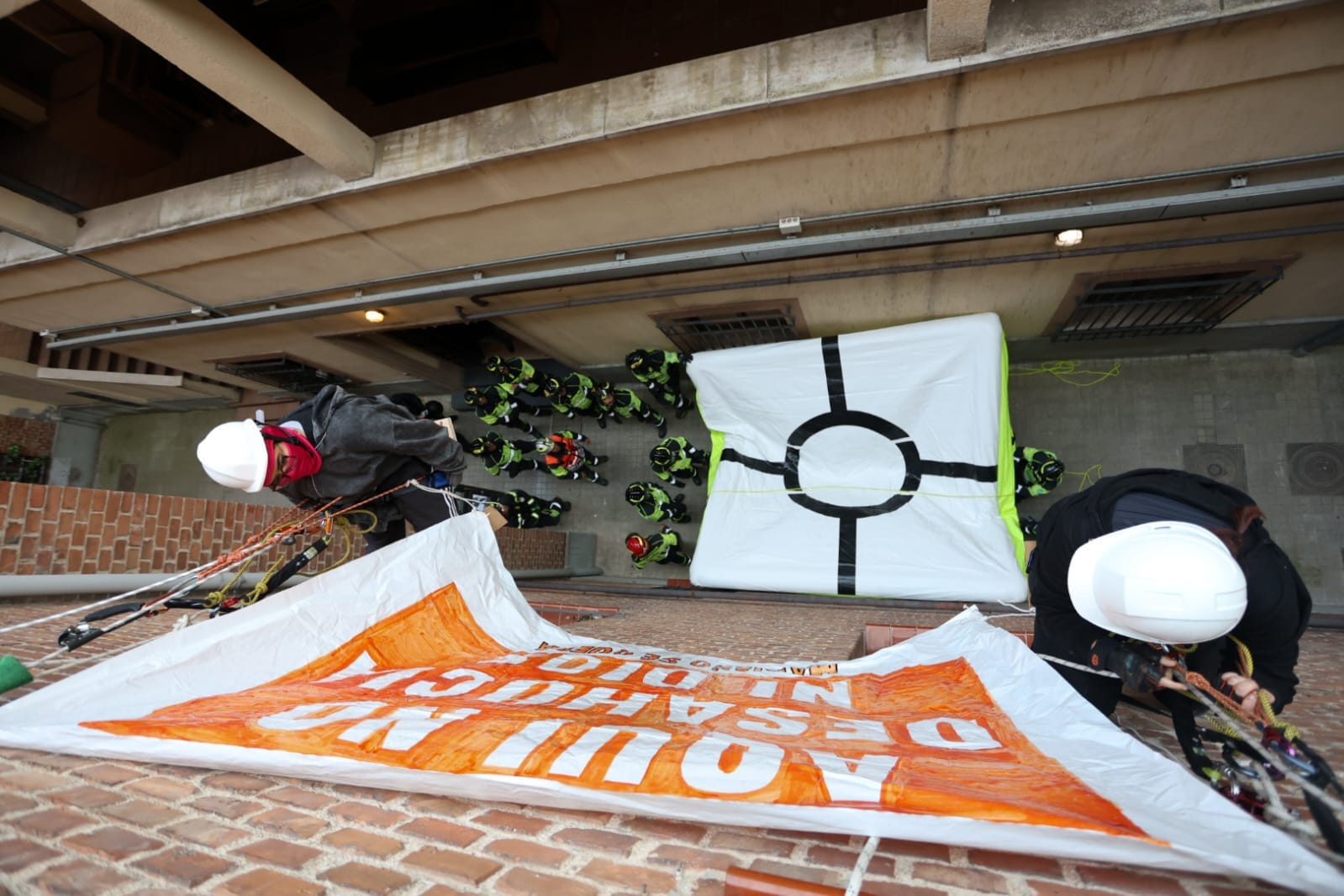 Activistas de Acciones en Alturas colgados de la puerta del hogar de Mariano en Madrid. Foto: @InquilinatoMad (X)