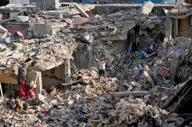Un hombre que regresa a su pueblo tras el anuncio del acuerdo muestra el signo de la victoria sobre los escombros de su casa destruida en la ciudad de Nabatiyeh, en el sur del Líbano, el martes. Foto: AP