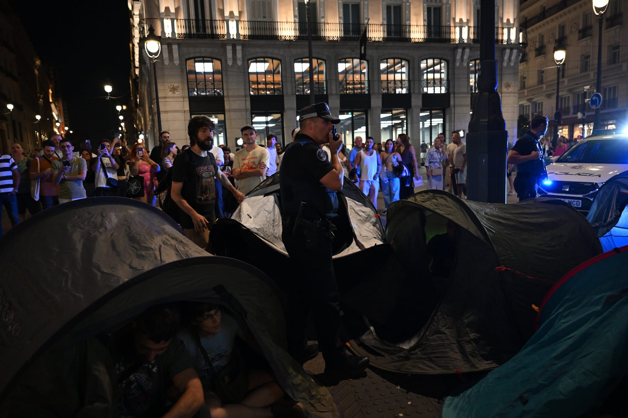Un agente de la Policía Municipal de Madrid acude a intentar retirar las tiendas de campaña en Sol durante los primeros instantes de la acampada por la vivienda. Foto: @DaniGagoPhoto (X)