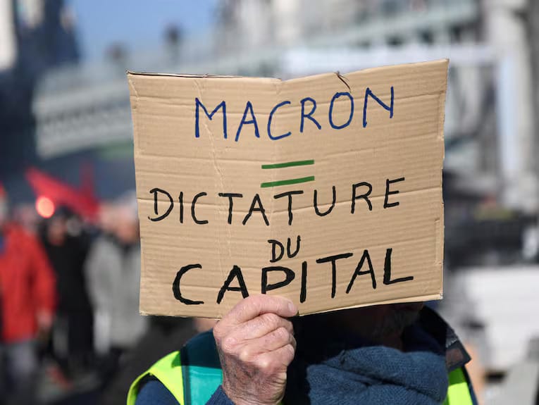 Imagen de archivo de un manifestante sosteniendo un cartel en una protesta e n Francia: “Macron: dictadura del capital”. Foto: Le Point.