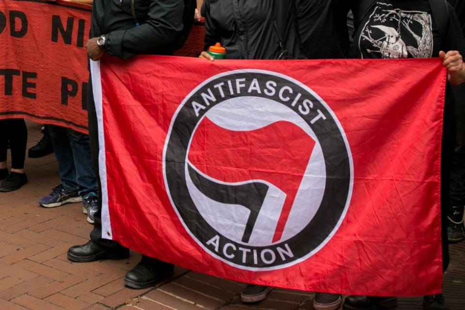 Imagen de archivo de manifestantes antifascistas sosteniendo una bandera. Foto: vía izquierdaweb.com 