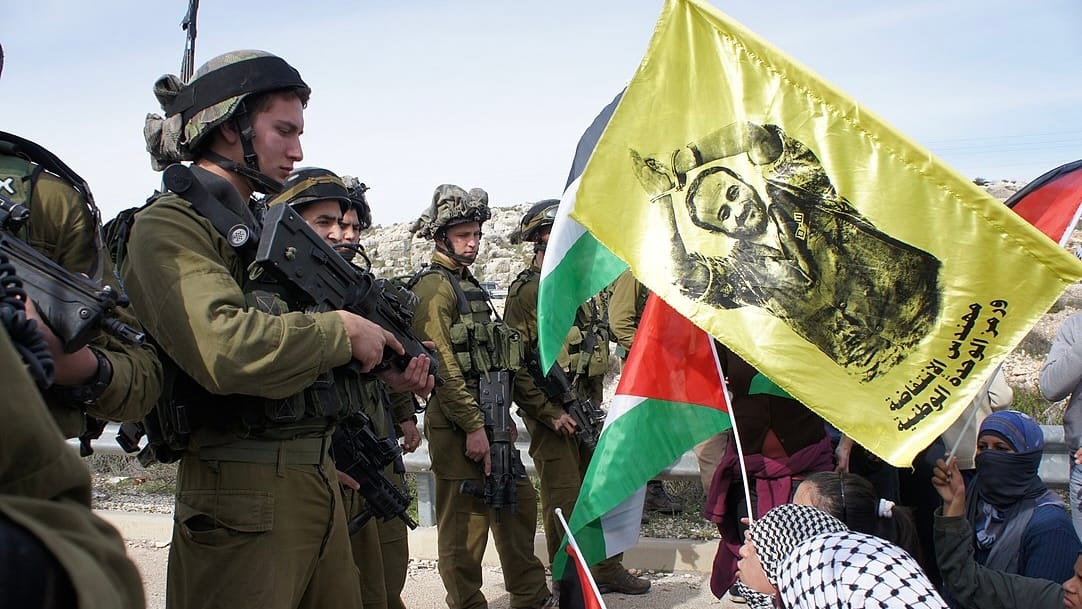 Manifestación contra el robo de tierras palestinas en 2012 luce una bandera del preso político Marwan Barghouti. Foto: Wikimedia Commons
