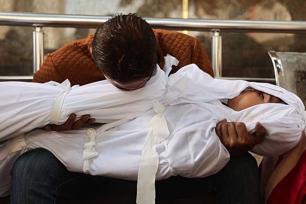 Imagen de archivo de un hombre gazatí sosteniendo a un ser querido asesinado. Foto: Gaza Notifications
