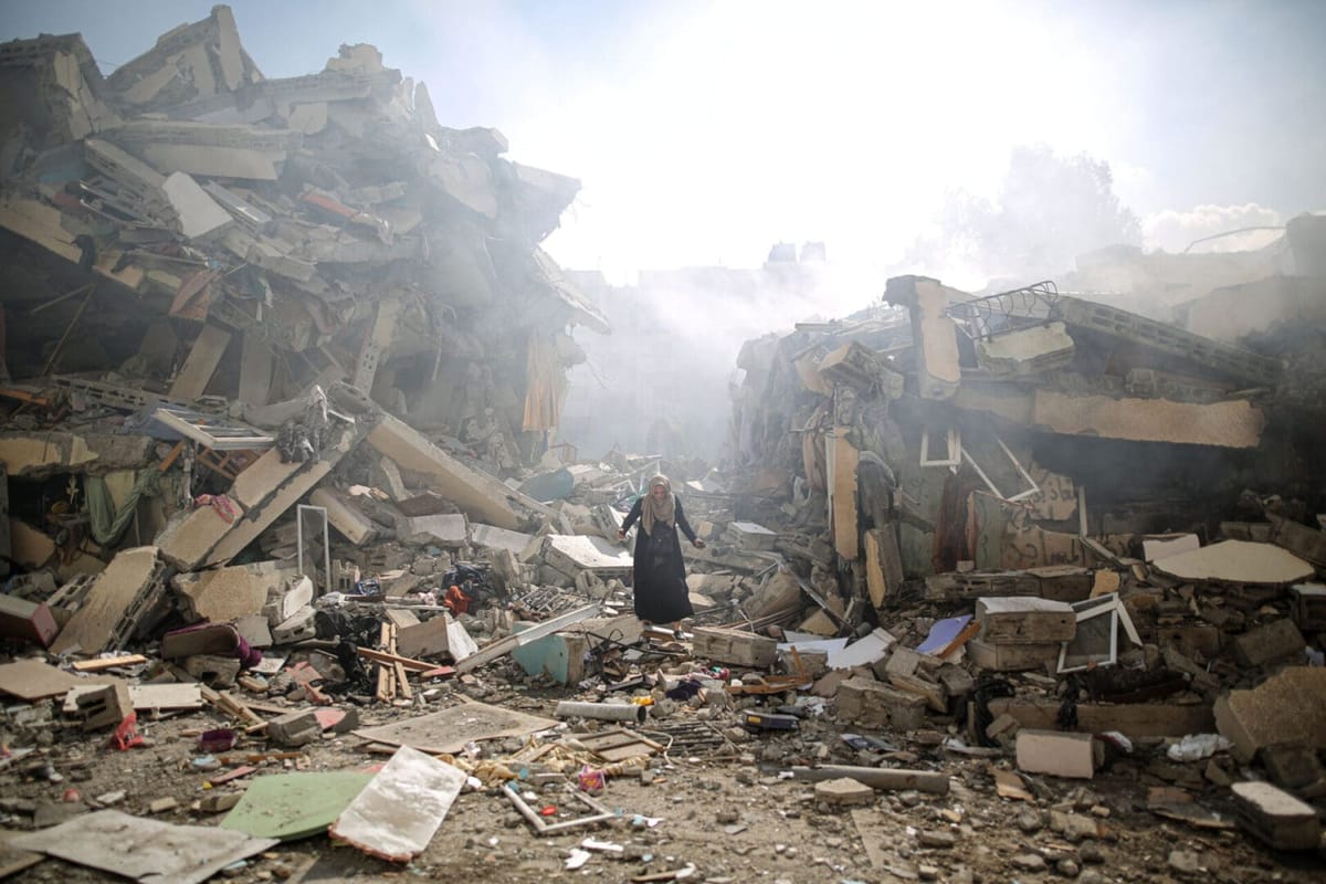 Una mujer camina sobre los escombros de Gaza. Foto: amnestyusa.org