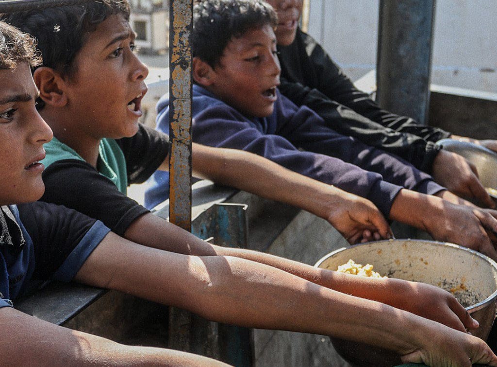 Adolescentes gazatíes en un reparto de comida. Foto: Al Jazeera