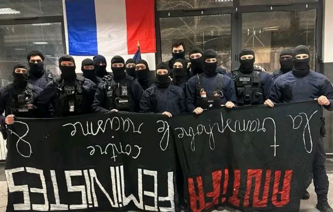 Policías franceses con el rostro cubierto posan con una pancarta arrebatada a feministas antifascistas. Foto: vía blast-info.fr