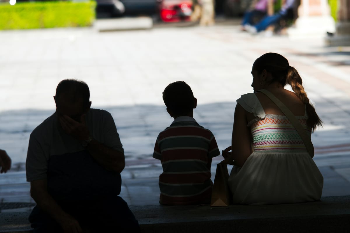 Imagen de archivo de un niño sentado junto a adultos. Foto: Jose Manuel Esp/Unsplash