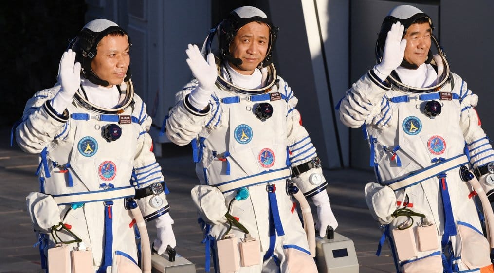 Los astronautas Tang Hongbo, Nie Haisheng y Liu Boming saludan durante una ceremonia de despedida antes de abordar la nave espacial Shenzhou-12. Foto: Greg Baker/AFP 