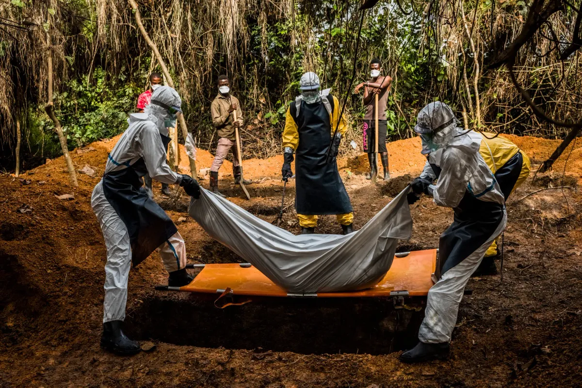 Un equipo entierra en Liberia a una mujer que murió antes de llegar a un centro que pudiera tratarla durante el brote de ébola de 2014. Foto: Daniel Berehulak - NYT