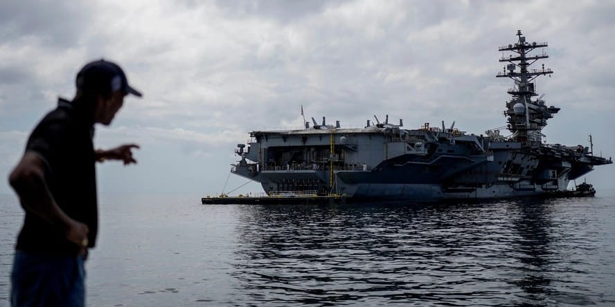 Un trabajador señala el portaaviones estadounidense USS Nimitz atracando en el golfo de Panamá, 30 de marzo de 2026. Foto: Matias Delacroix-AP