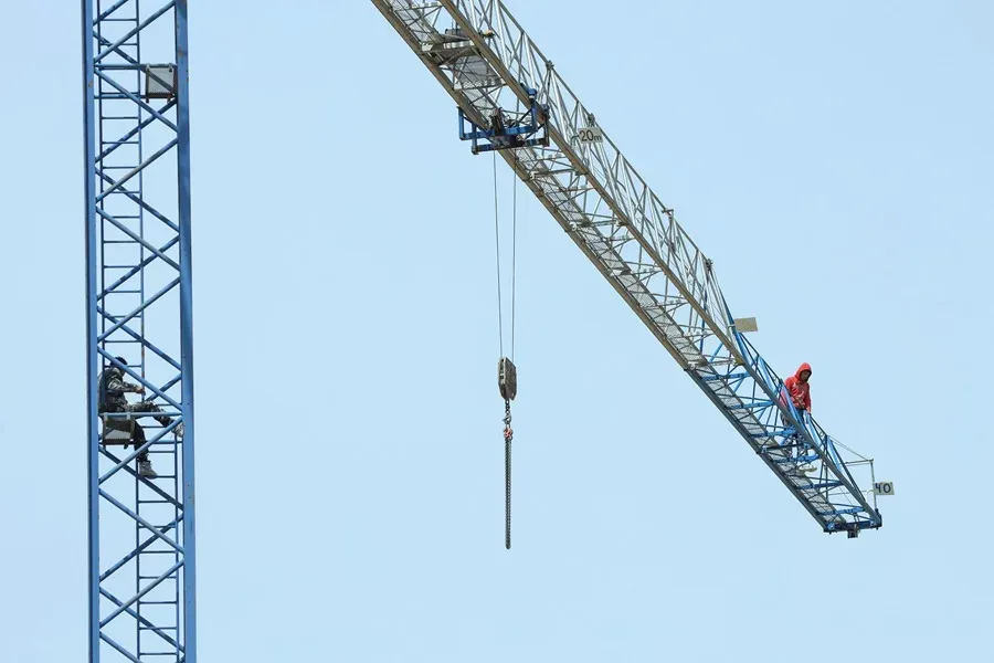 Empleados de los detenidos subidos a una grúa en Burgos como protesta por sus condiciones. Foto: EFE