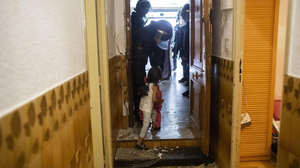 Un agente de la Policía Nacional “acompaña” a una niña tras desahuciarla a ella y a su familia de su casa. Foto: elperiodico.com 