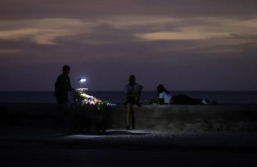 Un vendedor camina durante un apagón, el 8 de julio, en La Habana. Foto: EFE-Ernesto Mastrascusa